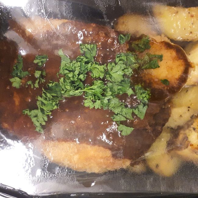 Ost och skinkfylld schnitzel serveras med stekt potatis och gorgonzolasås